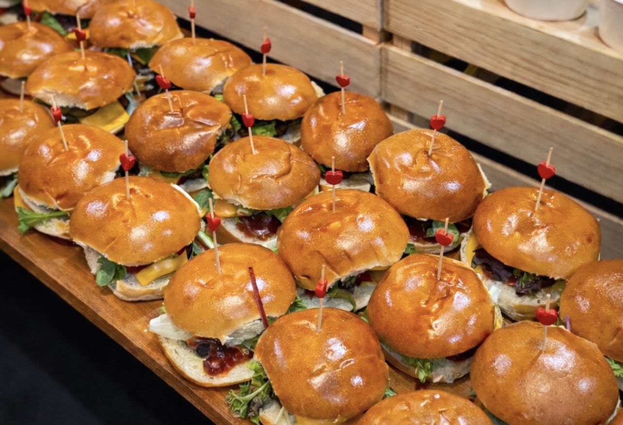 Gourmet sliders on a wooden serving board